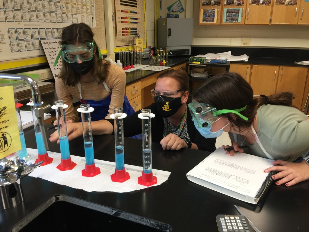 teacher collaborating with chem students